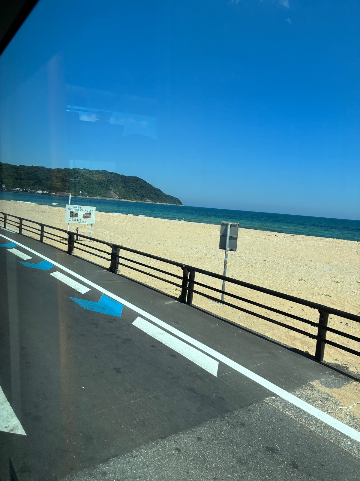 車窓から見た砂浜と青い海